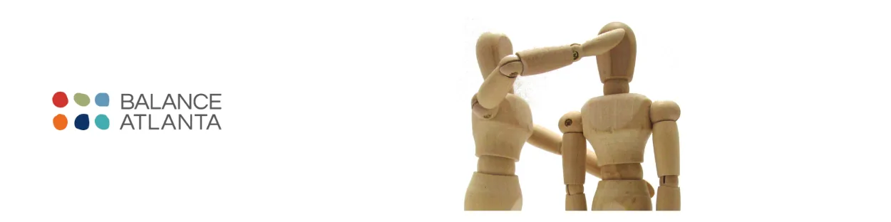 Balance Atlanta logo at left; two wooden jointed mannequins on the right, one placing a hand on the other's head as if adjusting posture.