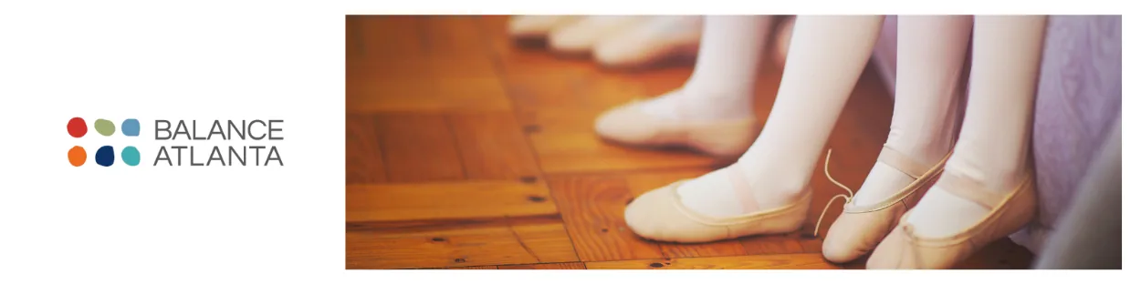 Close-up of dancers' feet in ballet slippers lined up on a wooden floor