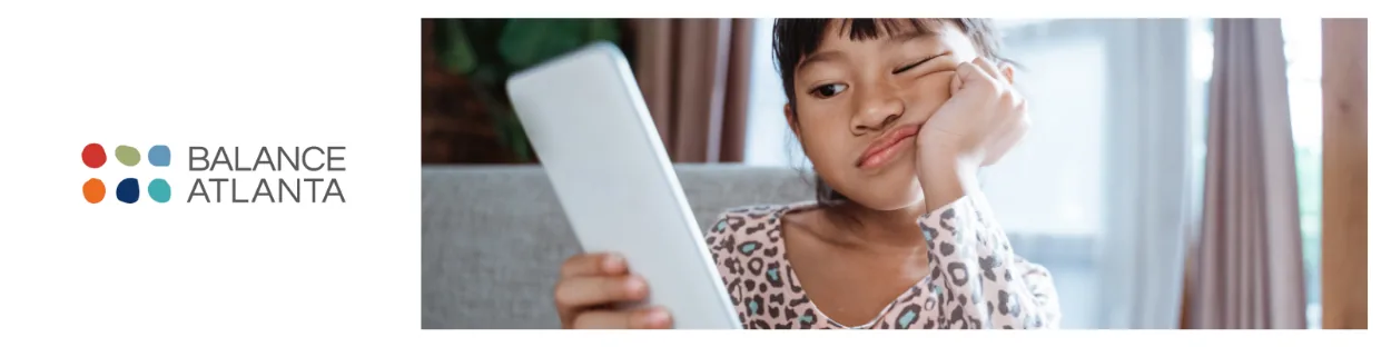 Child holding a tablet, resting head on hand with a bored expression, with the Balance Atlanta logo visible at left.