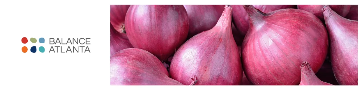Close-up of red onions filling the frame with the Balance Atlanta logo at left on a white background.