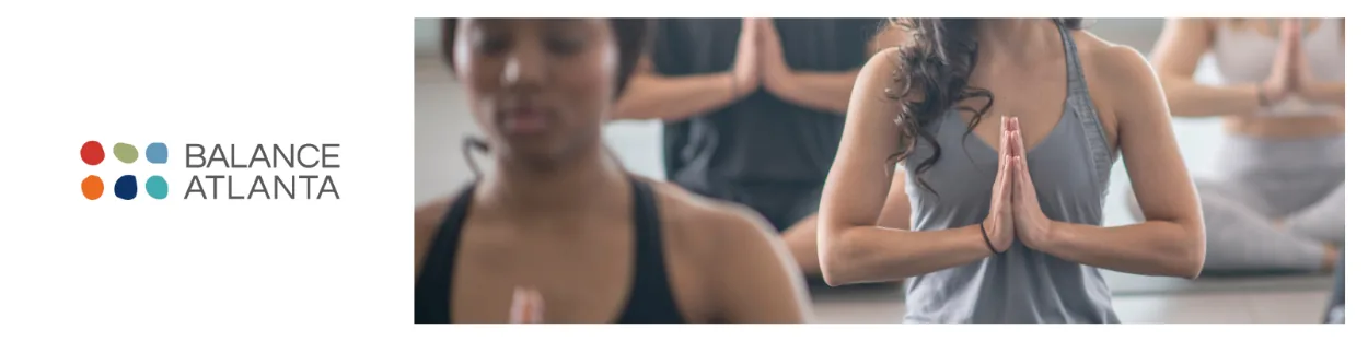 People seated in a yoga/meditation class holding hands in a prayer position, with the Balance Atlanta logo visible at left.