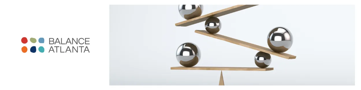 Balance Atlanta logo at left with stacked wooden planks and reflective metal spheres balancing on the right.