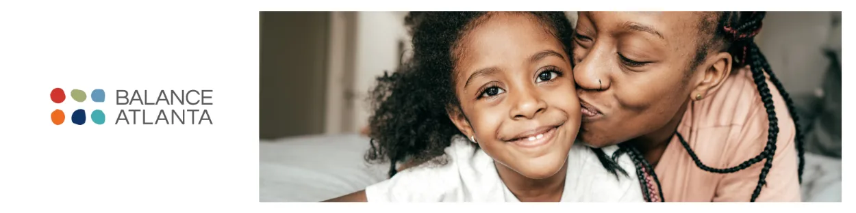 Woman kissing a smiling child on the cheek, with the Balance Atlanta logo visible to the left.