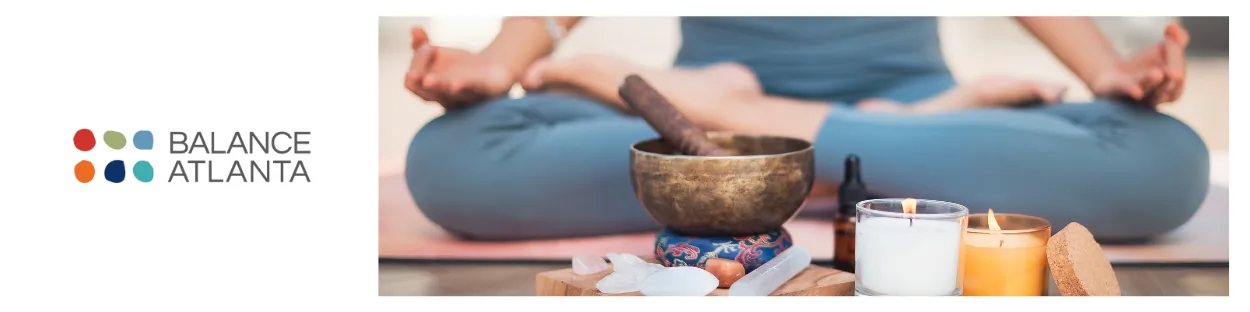 Balance Atlanta logo on the left and a person seated cross-legged in meditation with a singing bowl, crystals, candles, and an essential oil bottle.