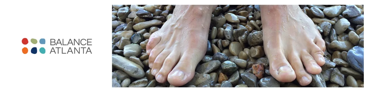 Balance Atlanta logo beside bare feet standing on smooth pebbles