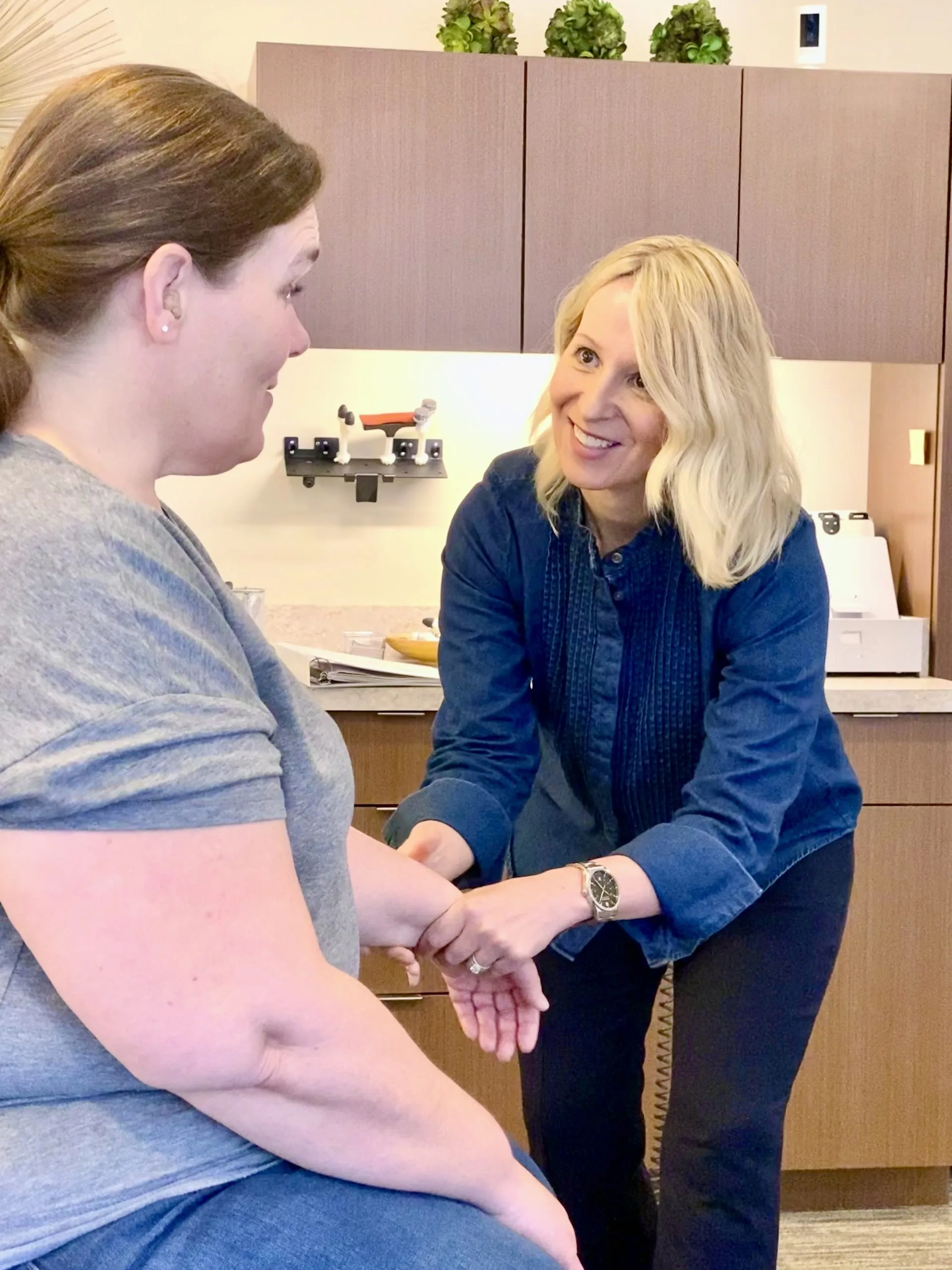 Chiropractor examining a patient's wrist during a consultation for arthritis.