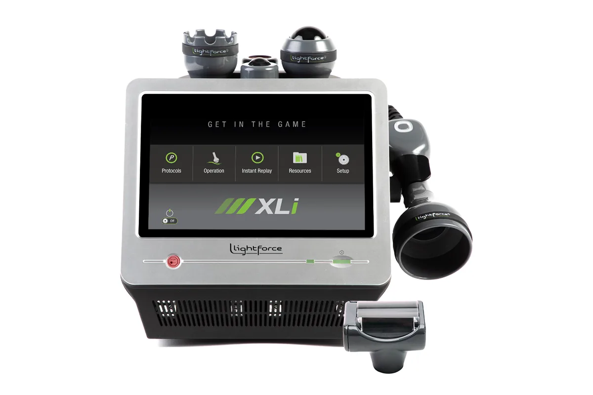 Therapeutic LightForce XLi laser machine with touchscreen and multiple hand applicators, shown for chiropractic treatment of wrist pain and carpal tunnel.