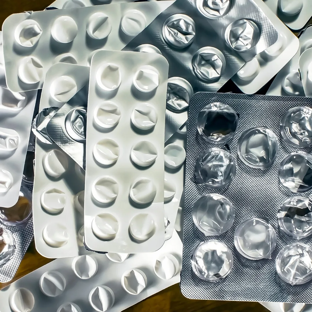 Several empty and partially used medication blister packs with crumpled foil backing.