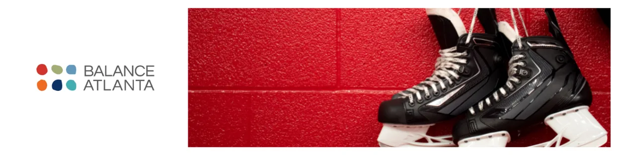 Black ice hockey skates resting against a red cinderblock wall with the Balance Atlanta logo visible on the left.
